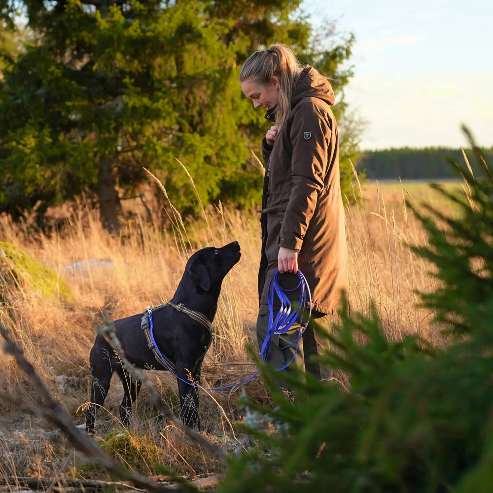 Miljöbild svart labrador och tjej i skogen med junies spårlina biothane 5 meter blå #color_blue