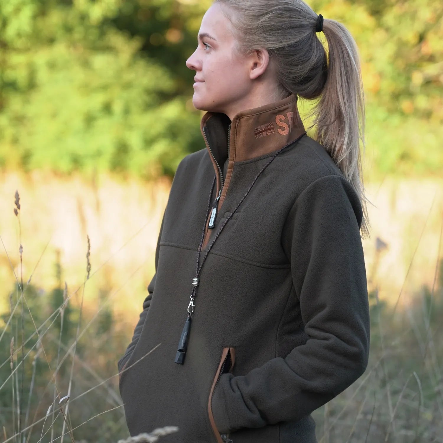 Miljöbild tjej på fält med sporting saint fleecetröja half zip khaki #color_khaki